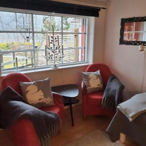 a living room with two chairs and a window at Torpet Gårdsvägen in Hammar