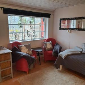 a bedroom with two chairs and a bed and a window at Torpet Gårdsvägen in Hammar