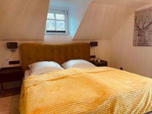 RangersdorfにあるDas schräge Häuslのベッドルーム1室(大型ベッド1台、黄色い掛け布団付)
