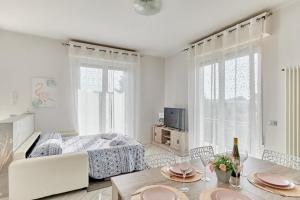 Sala de estar blanca con cama y mesa en App. Mimosa Minerva Holiday Home, en Manerba del Garda