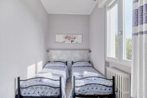 two twin beds in a room with a window at App. Mimosa Minerva Holiday Home in Manerba del Garda