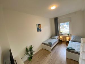 een woonkamer met 2 bedden en een raam bij Gemütliches Apartment Remscheid in Remscheid