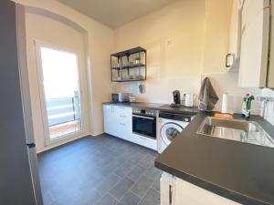 a kitchen with a sink and a washing machine at Gemütliches Apartment Remscheid in Remscheid