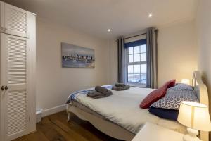 a bedroom with a bed and a window at Sea View Cottage, Sandgate in Sandgate