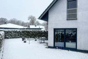 a snow covered yard next to a white building at Ferienhaus Walow in Walow
