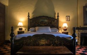 a large bed in a bedroom with two lamps at Hotel Museo Mayan Inn in Chichicastenango