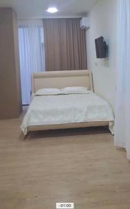 a bedroom with a large bed with white sheets and pillows at Almare Batumi in Batumi