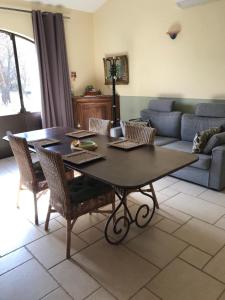 a living room with a table and a couch at Le Bois De La Cour in Roussillon