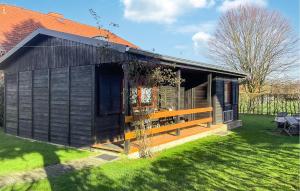 a black shed with a deck on the grass at Amazing Home In Oberelbert With 2 Bedrooms in Oberelbert