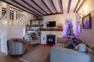 a living room with a christmas tree and a fireplace at Sea View Cottage, Sandgate in Sandgate