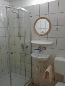 a bathroom with a shower and a sink and a mirror at Pokoje Dom Turysty Sanok 24h in Sanok