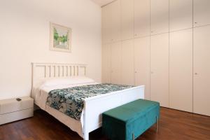 um quarto com uma cama branca e um banco verde em Summer Breeze Family Aparment by Wonderful Italy em Bari