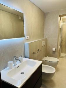 W łazience znajduje się umywalka, toaleta i lustro. w obiekcie Mascherone Apartment w Wenecji
