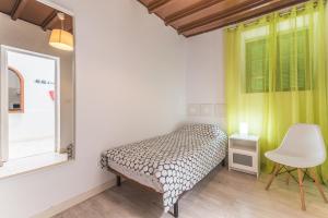 メレナラにあるHome2Book Oceanfront Bliss in Taliarteのベッドルーム1室(ベッド1台、窓、椅子付)