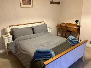 a bedroom with a bed with a table and a desk at Yew Tree House, Bed & Breakfast in Colchester in Lexden