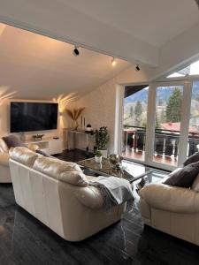 a living room with two couches and a tv at In der Leite in Oberstdorf