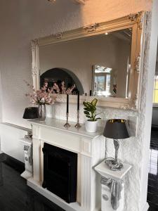 a fireplace in a living room with a mirror at In der Leite in Oberstdorf