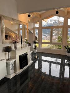 a large living room with a fireplace and windows at In der Leite in Oberstdorf