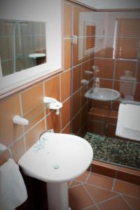 y baño con lavabo blanco y ducha. en LêPlek Guesthouse, en Saldanha