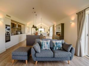 a living room with a blue couch and a kitchen at Gallops in East Ilsley