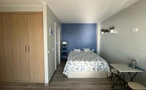 a bedroom with a bed and a blue wall at Estudio con Impresionantes Vistas al Mar in Blanes