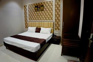 een slaapkamer met een bed met een houten hoofdeinde bij Hotel Swastik 5 Minutes walking From Golden Temple in Amritsar