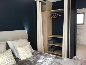 a bedroom with blue walls and a bed with pillows at Au Coeur d'Omaha Beach - Colleville-sur-Mer - Gîte 1 in Colleville-sur-Mer