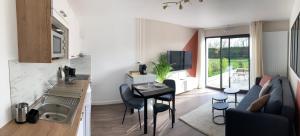 eine Küche und ein Wohnzimmer mit einem Sofa und einem Tisch in der Unterkunft Au Coeur d'Omaha Beach - Colleville-sur-Mer - Gîte 1 in Colleville-sur-Mer