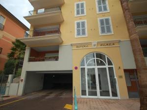 a large yellow building with a door and balcony at Charmant 2P Climatisé en Centre-Ville avec Terrasse et Parking Privé - FR-1-196-336 in Menton
