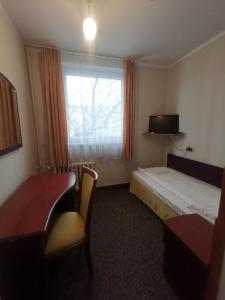 a hotel room with a bed and a window at Pokoje Dom Turysty Sanok 24h in Sanok