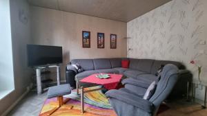 a living room with a couch and a tv at Ferienwohnung Holzmann in Wernigerode