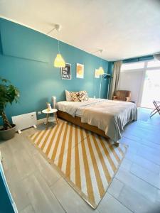 a bedroom with a bed and a blue wall at Villa do Sol in Carcavelos
