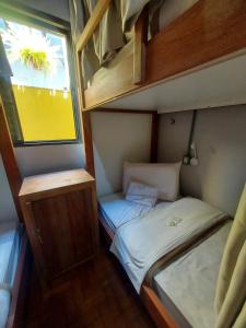 mały pokój z 2 łóżkami i oknem w obiekcie HOSTEL BADULACK w mieście Capitólio
