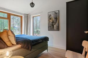 a bedroom with a bed and a window at Nieuwe luxe villa in het bos in Zorgvlied