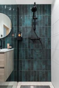a bathroom with a shower with green tile at Nieuwe luxe villa in het bos in Zorgvlied