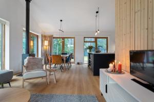 a living room with a fireplace and a dining room at Nieuwe luxe villa in het bos in Zorgvlied