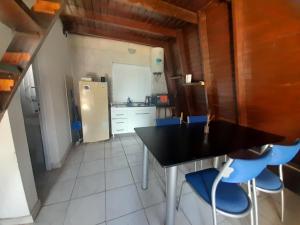 eine Küche mit einem schwarzen Tisch und blauen Stühlen in der Unterkunft Chacaimanta RIVERA in Rivera