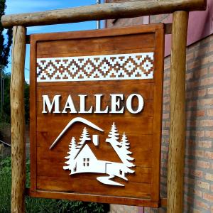 Ein Schild, auf dem steht, Malibu mit einem Haus und Bäumen. in der Unterkunft Cabañas Malleo in Junín de los Andes