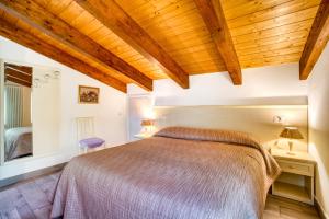 ein Schlafzimmer mit einem großen Bett und Holzdecken in der Unterkunft Casavacanzelemore - Casa Zara in Valfabbrica