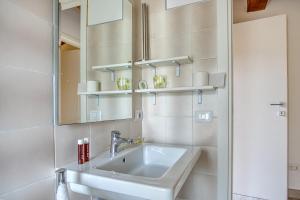 ein weißes Badezimmer mit einem Waschbecken und einem Spiegel in der Unterkunft Casavacanzelemore - Casa Zara in Valfabbrica