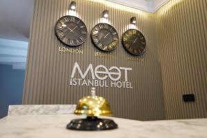 3 horloges sur un mur avec les mots non istanbul hotel dans l'établissement Meet İstanbul Hotel Kadikoy, à Istanbul