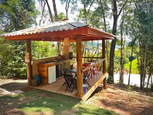einen Pavillon mit einem Tisch und Stühlen auf einer Terrasse in der Unterkunft Casa de Vidro - Vila Mágica in Bueno Brandão