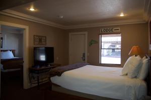 a bedroom with a large bed and a television at The Lodge on Route 66 in Williams