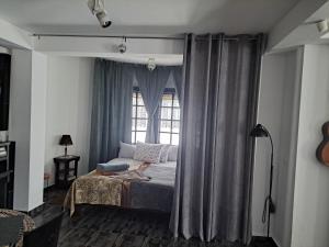 een slaapkamer met een bed en een raam bij Gnezdo Studio Apart in Shipka