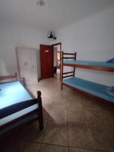 a room with two bunk beds and a hallway at Hostel Canto da Alegria in Itanhaém