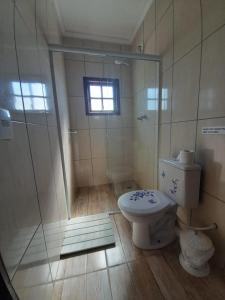 a bathroom with a shower and a toilet at Hostel Canto da Alegria in Itanhaém