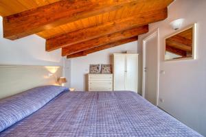 a bedroom with a bed and wooden ceilings at Casavacanzelemore - Casa Zoe in Valfabbrica
