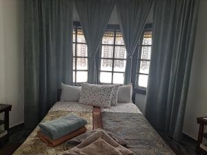 een slaapkamer met een bed met kussens en een raam bij Gnezdo Studio Apart in Shipka