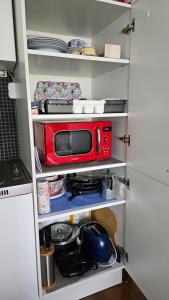 a red microwave sitting on a shelf in a kitchen at Orientalische Wohnung in Meckenheim