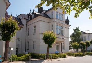uma grande casa branca com uma torre em Ahlbeck, Schloss Hohenzollern - WG 21 em Ahlbeck
